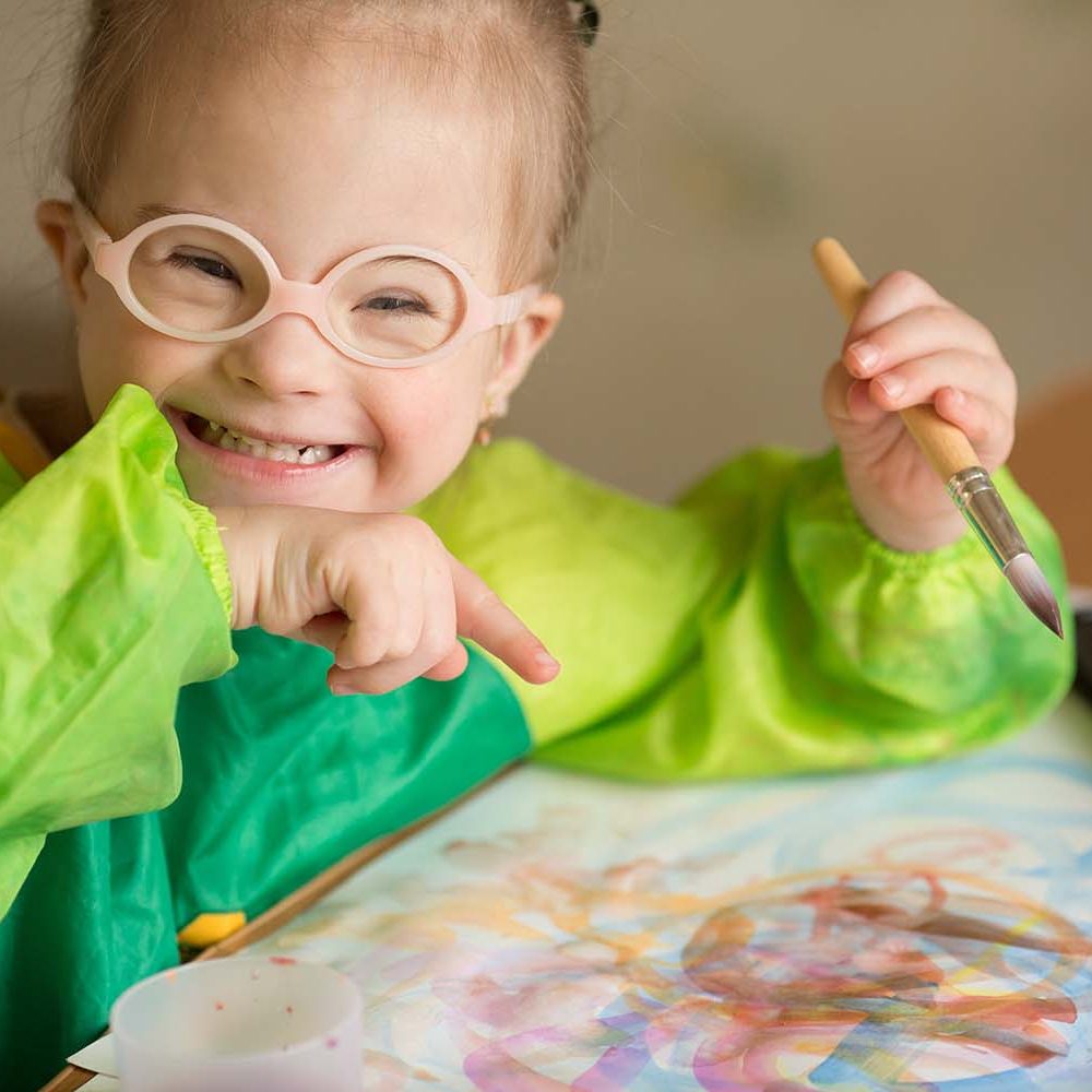 Girl with Down syndrome covered in paint when drawing